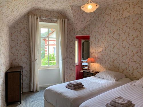 une chambre avec deux lits et une fenêtre dans l'établissement Villa in Saint-Nectaire near Ski Slopes, cleaning included, à Saint-Nectaire