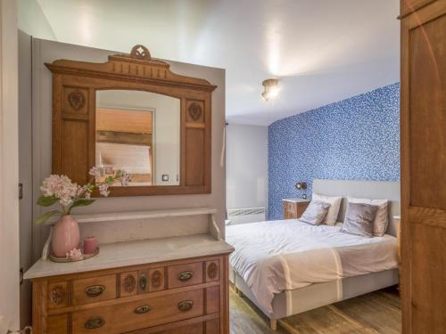 une chambre avec un lit et une commode avec un miroir dans l'établissement Holiday Home in Doulcon near Lac Vert Plage, cleaning included, à Dun-sur-Meuse