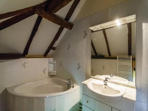 une salle de bain avec deux lavabos et une baignoire dans l'établissement Holiday Home in Blanquefort with Private Pool, cleaning included, à Blanquefort-sur-Briolance