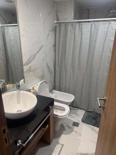 a bathroom with a sink and a toilet and a shower at Departamento espectacular con balcón panorámico en piso alto in Villa Marini