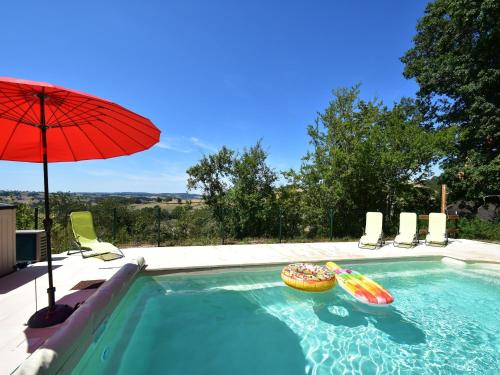 une piscine avec un parasol et deux beignets dedans dans l'établissement Mansion in Cuzy with Shared Pool, cleaning included, à Cuzy