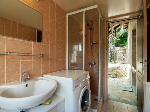une salle de bain avec une machine à laver et un lavabo dans l'établissement Cottage near Lac du Causse with Terrace, cleaning included, à Chasteaux