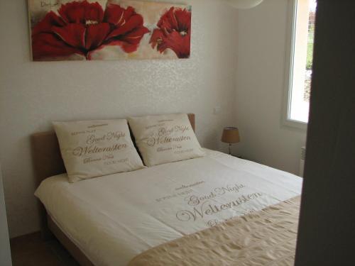 un lit blanc avec deux oreillers dessus dans l'établissement Poolside Apartment in Segonzac, cleaning included, à Segonzac