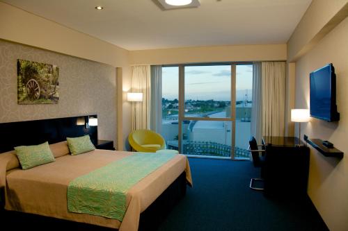 a hotel room with a bed and a large window at Gala Hotel y Convenciones in Resistencia