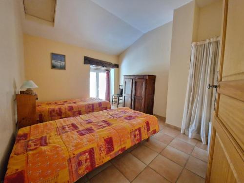 une chambre avec deux lits et une fenêtre dans l'établissement Charming Stone House with Terrace, cleaning included, à Lussan