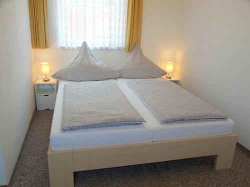 a bed in a room with two lamps on two tables at Fischer - Lindau Island in Lindau