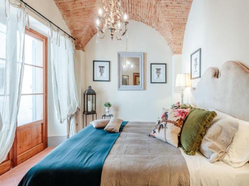 a bedroom with a large bed and a chandelier at Idyllic Coastal Escape in Sardinia in Marcialla