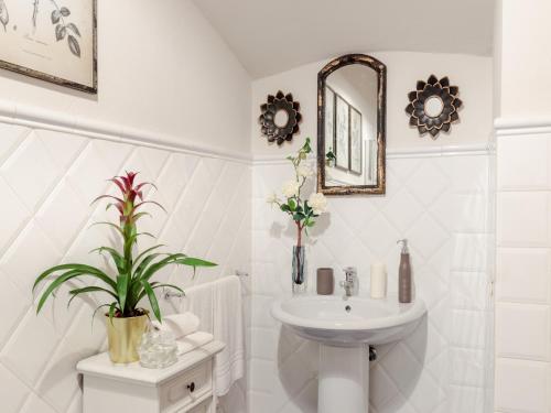 a white bathroom with a sink and a mirror at Idyllic Coastal Escape in Sardinia in Marcialla