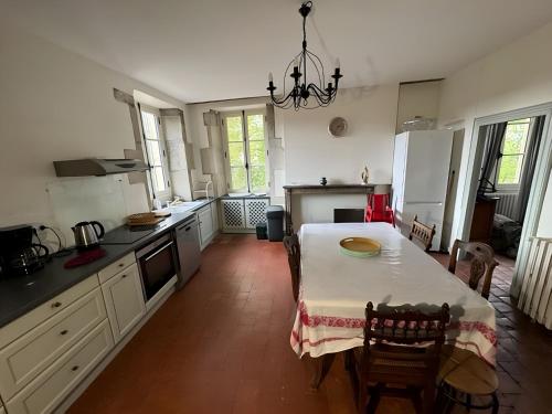 une cuisine avec une table et un chiffon de table blanc dans l'établissement Village House in Burgundy near Vézelay Basilica, à Vault-de-Lugny
