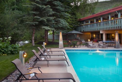 a pool with a pool table and chairs in front of a house at Evergreen Lodge at Vail in Vail
