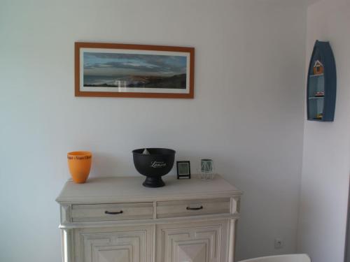 un meuble en bois avec un vase au-dessus dans l'établissement Holiday Home in Audresselles by Seacoast, cleaning included, à Audinghen