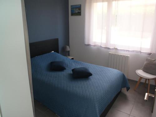 une chambre avec un lit bleu avec deux oreillers dessus dans l'établissement Holiday Home in Audresselles by Seacoast, cleaning included, à Audinghen