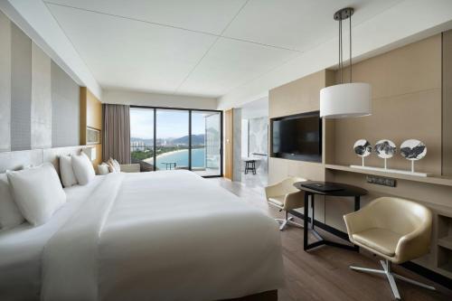 a hotel room with a large bed and a desk at The Shanhaitian Resort Sanya, Autograph Collection in Sanya