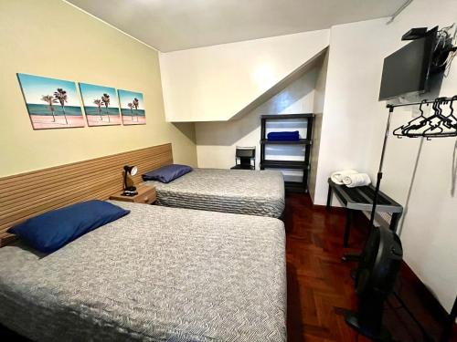 a hotel room with two beds and a flat screen tv at Lima Mini Aparts Monterrico - Cerca Embajada EEUU in Lima