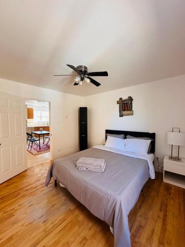 a bedroom with a bed with a ceiling fan at Charming & Cozy Family Home Near Plaza, Movie hall in Cornwall