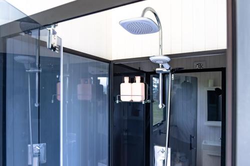 a bathroom with a shower with a glass door at Farm Stay Tiny House by Tiny Away in Braidwood
