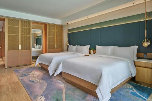 two beds in a hotel room with a leopard on the floor at The St. Regis Cap Cana Resort in Punta Cana