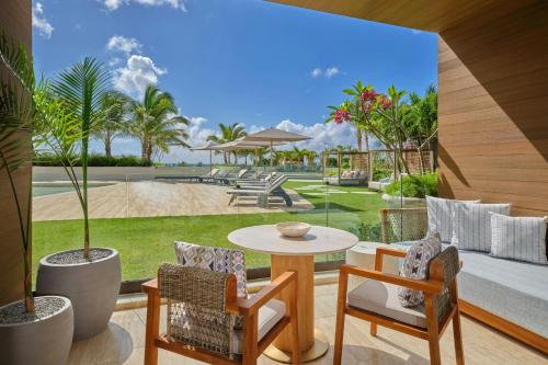 a patio with a table and chairs and a pool at The St. Regis Cap Cana Resort in Punta Cana