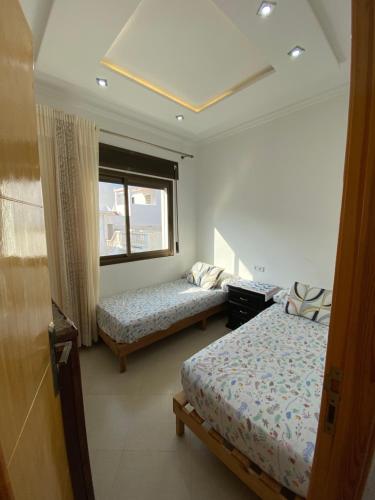 a bedroom with two beds and a window at Mekad in Oued Laou