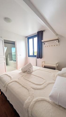 un grand lit blanc dans une chambre avec une fenêtre dans l'établissement Villa des Jardins, maison familiale 14 personnes proche plage, à Villers-sur-Mer