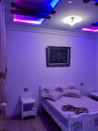 a bedroom with a bed with purple lights on it at 1 Sweet & Spacious House in Hammamet tunisia in Hammamet