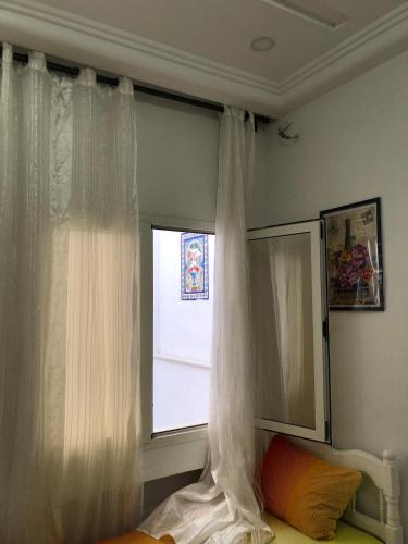 a bedroom with a window with white curtains at 1 Sweet & Spacious House in Hammamet tunisia in Hammamet