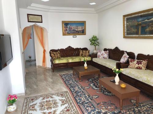 a living room with two couches and a tv at 1 Sweet & Spacious House in Hammamet tunisia in Hammamet