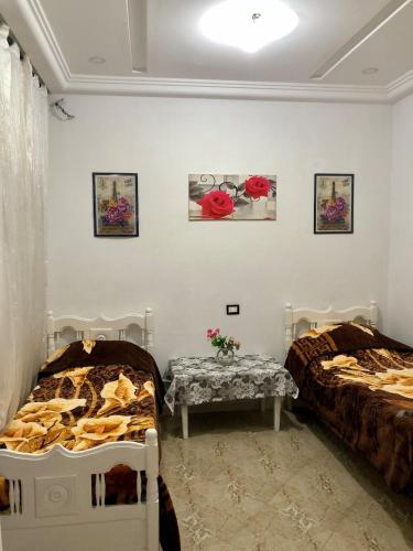 two beds in a room with flowers on the wall at 1 Sweet & Spacious House in Hammamet tunisia in Hammamet