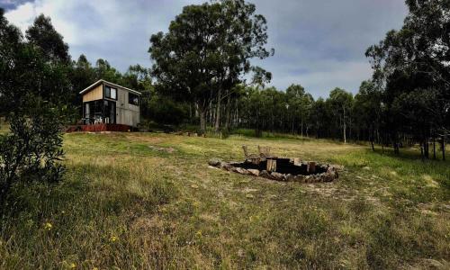 a house sitting on top of a grass field at Tiny Nanook - Kanimbla Valley by Tiny Away in Kanimbla