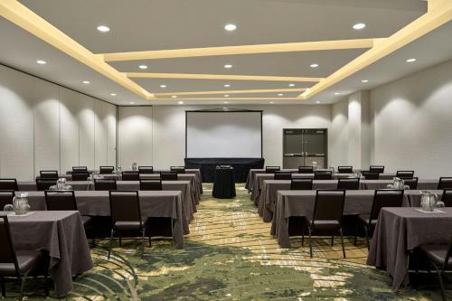 a conference room with tables and chairs and a screen at Element by Westin Vancouver Metrotown in Burnaby