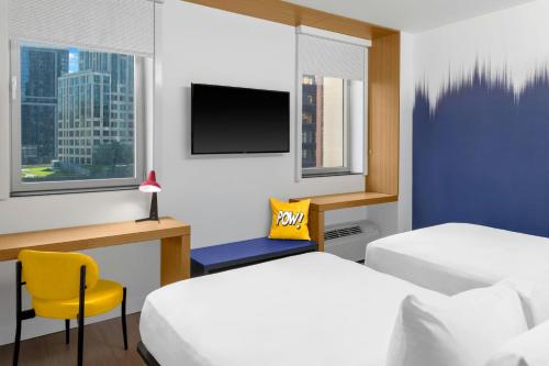 a hotel room with two beds and a tv at Aloft New York Brooklyn in Brooklyn