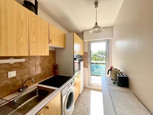 une cuisine avec un évier et une machine à laver dans l'établissement Appartement T2 idéalement situé à Arcachon - Proche plage, commerces et gare - Parking privé - FR-1-319-452, à Arcachon