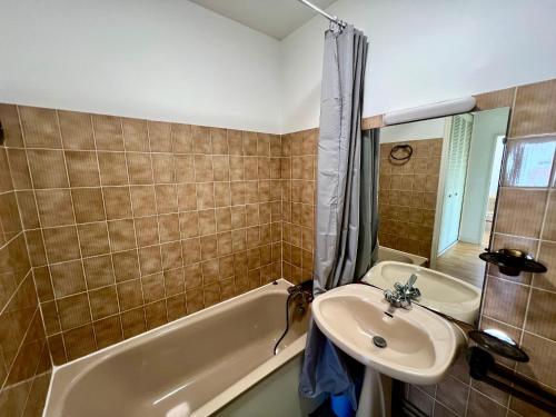 une salle de bain avec un lavabo et une baignoire et un lavabo dans l'établissement Appartement T2 idéalement situé à Arcachon - Proche plage, commerces et gare - Parking privé - FR-1-319-452, à Arcachon