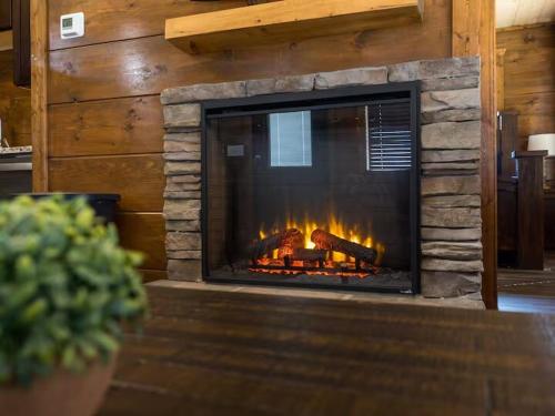 a fireplace in a living room with a fire in it at Center of It All Walk to Old Mill 3minDollywood in Pigeon Forge