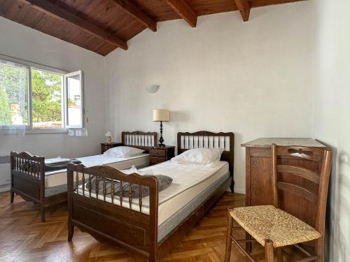 une chambre avec deux lits et une fenêtre dans l'établissement Villa 4 Pièces, 3 Chambres, Animaux Acceptés, Parking, WiFi, Proche Mer - FR-1-705-92, aux Mathes