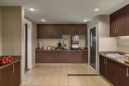a large kitchen with brown cabinets and a refrigerator at Residence Inn by Marriott Albany Washington Avenue in Albany
