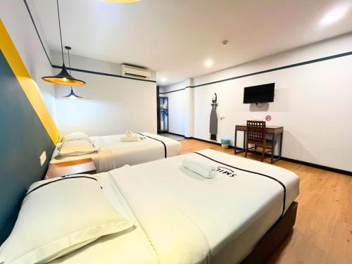 a hotel room with two beds and a television at Sky Hotel Cheras Maluri in Kuala Lumpur