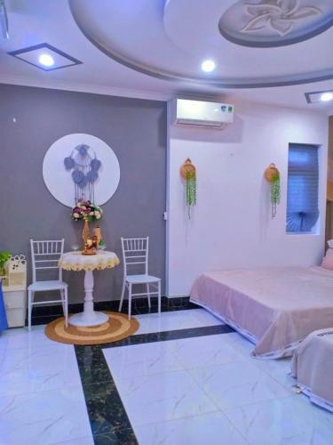 a bedroom with two beds and a table and chairs at Hoàng Nga Apartment Phan Thiết in Phan Thiet