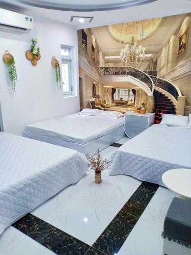 two beds in a large room with a room with at Hoàng Nga Apartment Phan Thiết in Phan Thiet