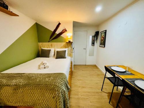 a bedroom with a bed with a green wall at Cine Studios PT in Setúbal