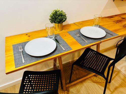 a wooden table with two white plates on it at Cine Studios PT in Setúbal