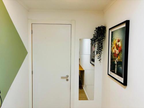 a hallway with a white door and a painting at Cine Studios PT in Setúbal