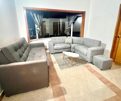 a living room with a couch and a table at Charming villa near to Medellín Metro and malls in Copacabana