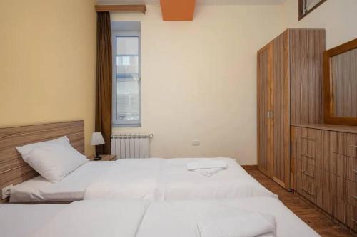 a bedroom with two white beds and a window at 7new building near Republic Square in Yerevan