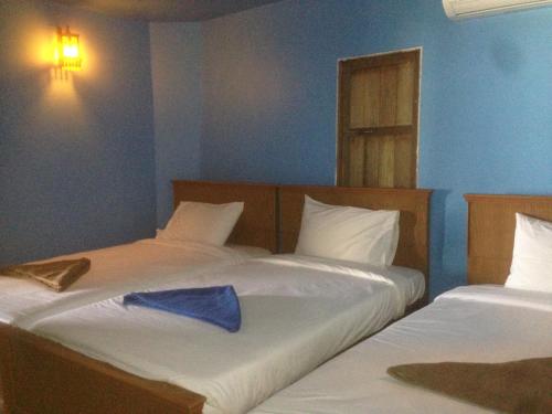duas camas num quarto com uma toalha azul em The Lazy Bar Guest House em Praia de Ao Nang