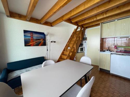 Il comprend un salon avec une table blanche et une cuisine. dans l'établissement Saint-Cyprien - Duplex 2 chambres avec terrasse et parking privé, vue sur le port - FR-1-309-507, à Saint-Cyprien