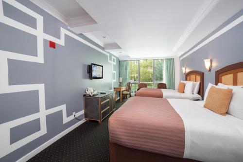 ニューヨークにあるホテル マルベリーのベッド2台とテレビが備わるホテルルームです。