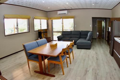 a living room with a table and a couch at Churaumi Village Motobu-Fuji-Karst in Motobu
