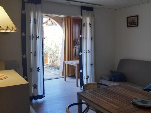 - un salon avec une table et une porte donnant sur une terrasse dans l'établissement Superbe T2 Rez-de-jardin, 4 Pers, Proche Mer, Parking Sécurisé, Animaux Acceptés - FR-1-798-21, à Leucate