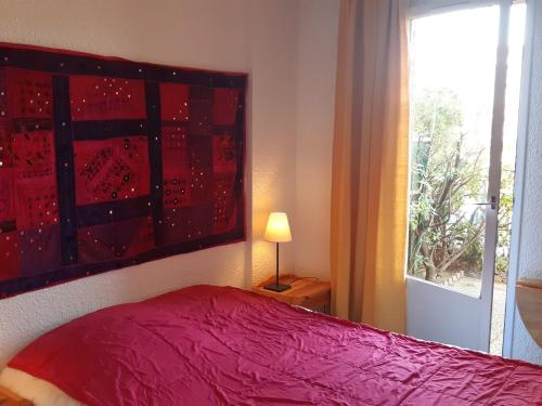 - une chambre avec un lit rouge et une fenêtre dans l'établissement Superbe T2 Rez-de-jardin, 4 Pers, Proche Mer, Parking Sécurisé, Animaux Acceptés - FR-1-798-21, à Leucate